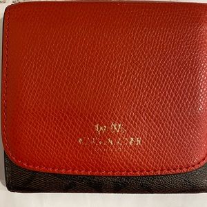 Red and canvas signature C Coach trifold wallet.